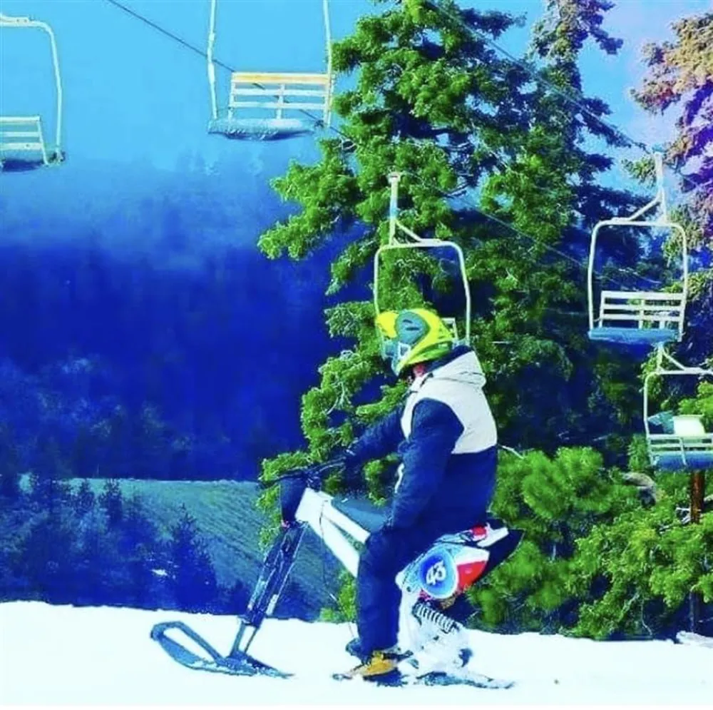Ski bike rider on the chairlift heading up the mountain
